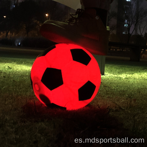 iluminando brillo en la pelota de fútbol oscuro